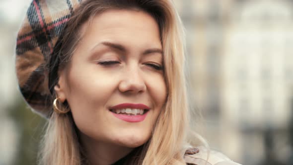 Stylish Parisian Businesswoman in Beret and Beige Trench Coat Shyly Smiles at the Camera. Portrait