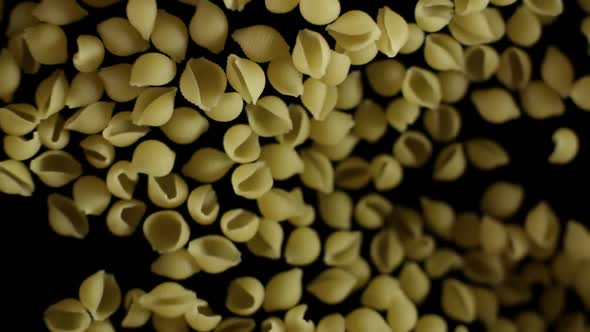 Shells Pasta Flies After Being Exploded Pile of Italian Macaroni Bouncing on Black Background