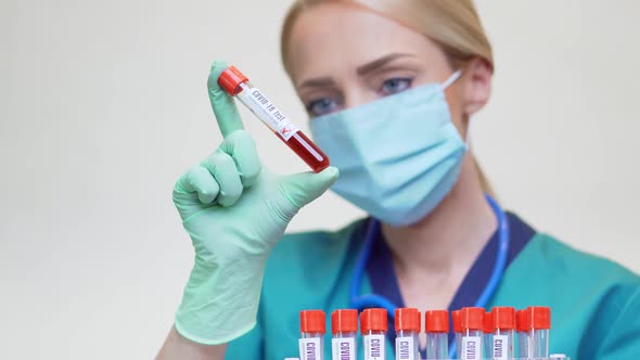 Medical Doctor Nurse Woman Wearing Protective Mask and Latex Gloves - Holding Blood Test Tube Rack