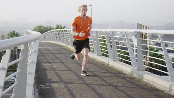 Sporty Caucasian man training on a bridge