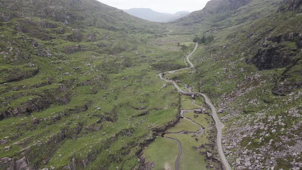 Lush Rocky Mountain Valley With Remote Road At Gap Of Dunloe In Kerry County, Ireland. - Aerial Pull