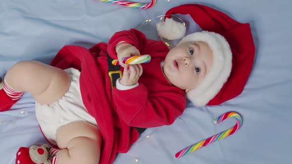 Christmas Portrait of Cute Little Newborn Baby Girl Wearing Santa Hat and Dress Winter Time