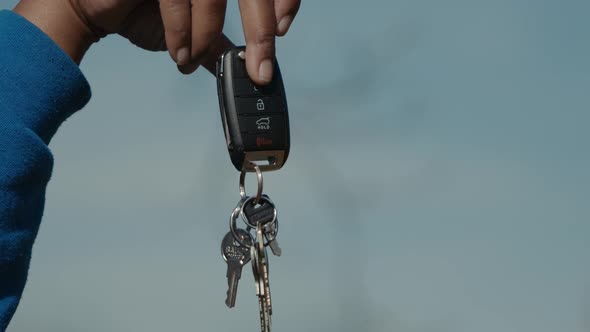 A set of keys being held up by a car key fob.