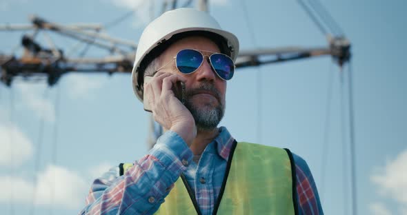 Engineer Coordinating on Phone on Construction Site