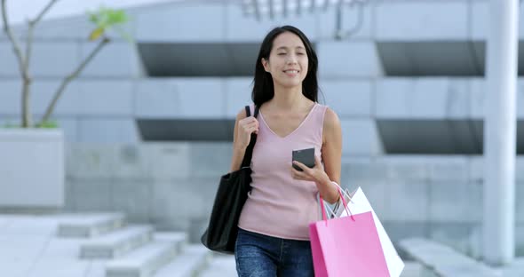 Woman holding shopping bag and walking in the outdoor 