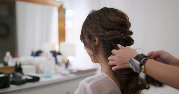 Stylist makes hair for bride