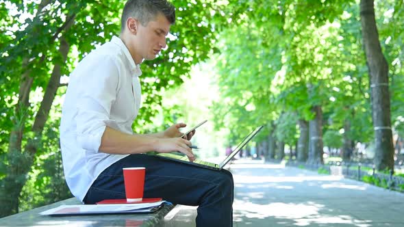 Businessman In Park And Using Smart Phone.