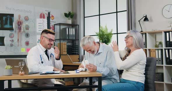 Doctor Smiling Together with Mature Family Couple During their Visit to clinic