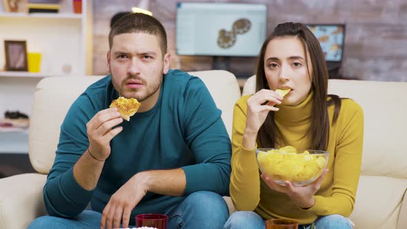 Scared Couple While Watching Tv and Eating Junk Food