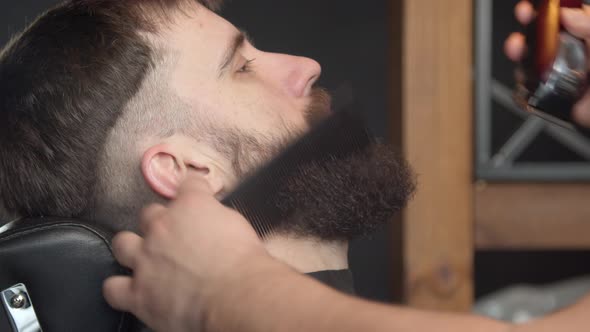 Barber Trimming Beard of Client