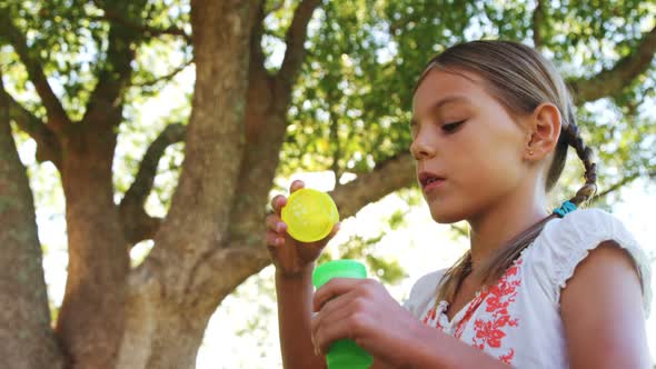 Girl blowing bubbles through bubble wand