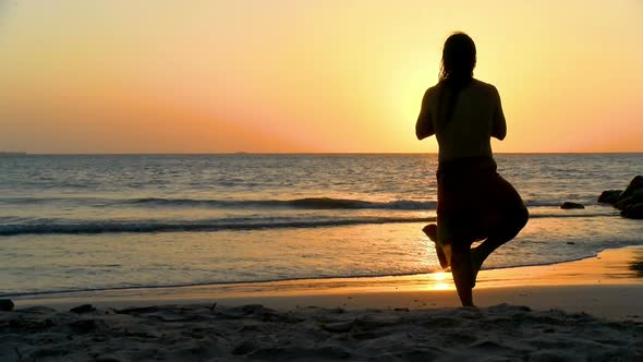 Young Man Practicing Relaxation Yoga Exercises by the Sea