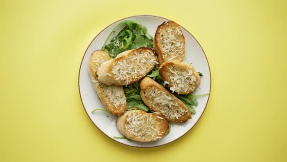 Slices of Garlic Cheese Bread Served on a Plate Arugula Leaves