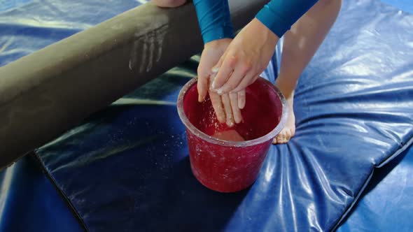 Gymnast putting chalk powder on her hands