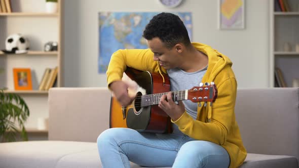 Happy African-American Teenager Playing Guitar, Enjoying Favorite Hobby, Leisure