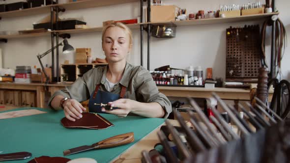 Caucasian Craftswoman Making Purse in Tannery