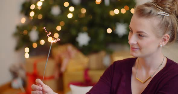 Smiling Young Woman Looking At Sparkler