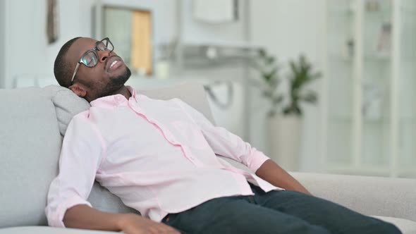 Tired Young African Man Taking Nap on Sofa 