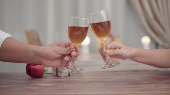 Close up romantic couple clink champagne or wine toast in a romantic dinner at restaurant