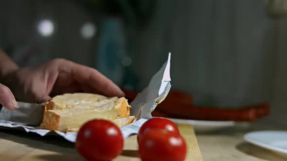 Closeup of Hand Cutting French Cheese Marquis Castello