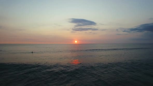 Flying Over Beautiful Ocean Waves And Surfers At Sunset. Aerial Footage