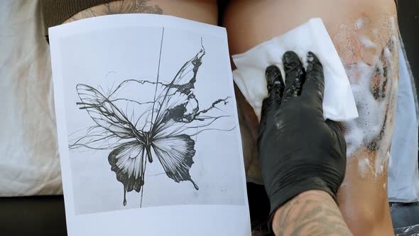 Tattoo Master Atomises a Sterile Solution on a Readymade New Tattoo on the Leg