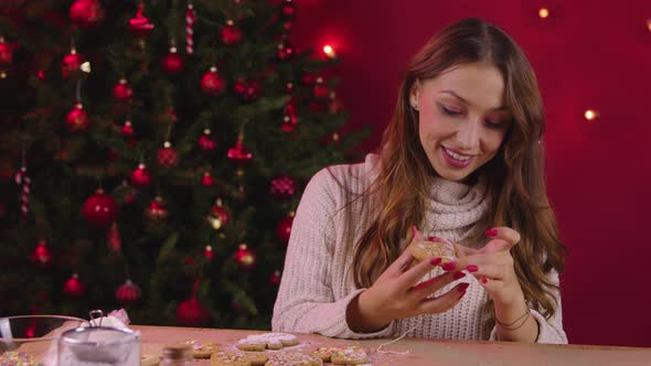 Cute Smiling Brunette Young Woman Hung Christmas Gingerbread on Linen String