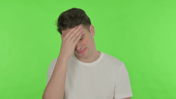 Young Man with Headache on Green Background