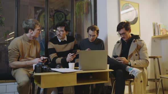 Businessmen Using Smartphones in Cafe. Relaxed Friends Hanging at Coffeehouse