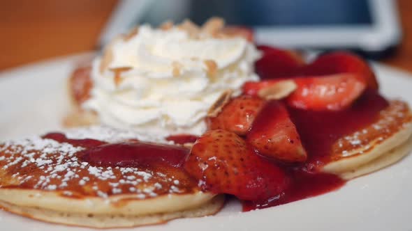 Close up pancake with strawberries, whip cream at cafe.