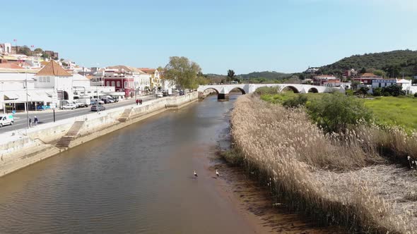Fly over river on quiet sunny day. Quaint view of Silves, Algarve, Portugal
