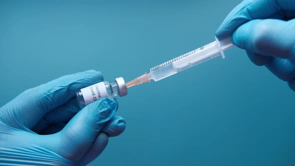 Doctor Hands in Medical Gloves Holds Syringe and Vaccine.