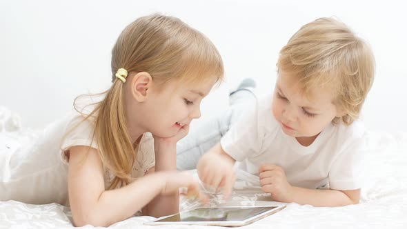 Sweet Caucasian Children Use Modern Gadget, Holding Tablet in Hands