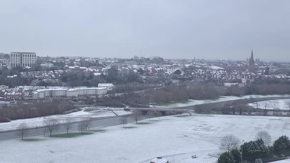 Track backwards drone shot of snowy Exeter over the River Exe CROP