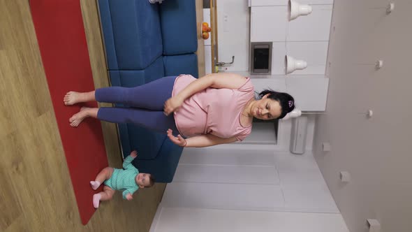 Overweighted Woman Doing Breathe Exercises While Her Baby Playing Next to Her