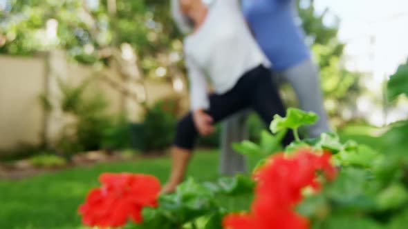 Trainer assisting senior woman in exercising 4k