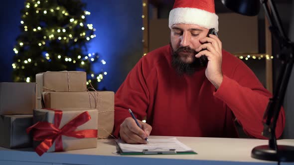 Dropshipping Owner Male Indian Santa Claus Works at Home Office at Night Taking Order By Phone and