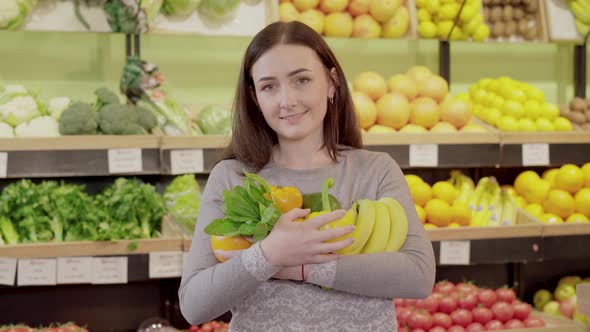 Portrait of Charming Brunette Girl Posing with Fuits in Grocery. Young Caucasian Woman Holding