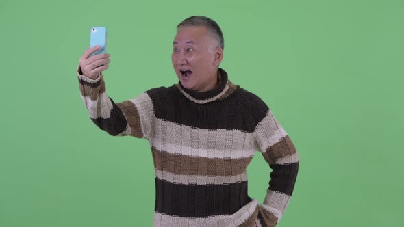 Happy Mature Japanese Man Taking Selfie