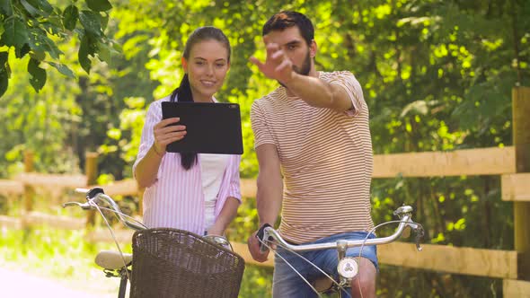 Couple with Tablet Pc and Bicycles at Summer Park