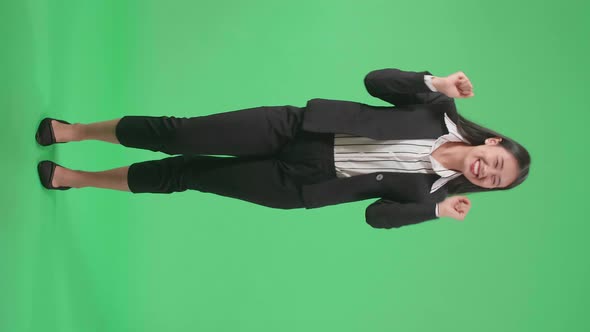 Full Body Of A Smiling Asian Business Woman Dancing While Standing On Green Screen