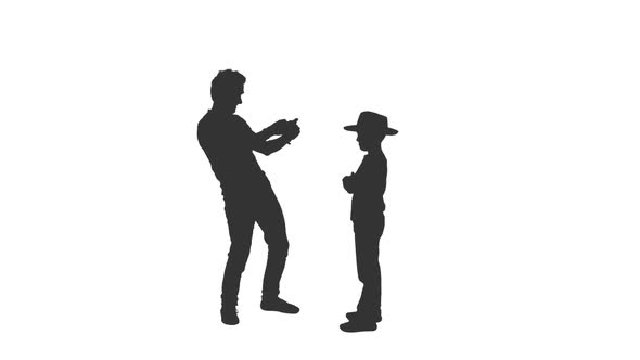 Silhouette of Man Takes a Photo of His Little Son With Mobile Phone alt