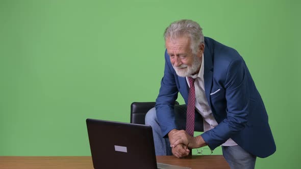 Handsome Senior Bearded Businessman Against Green Background