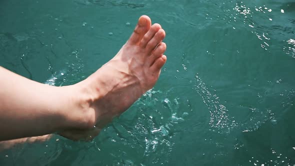 Girl Having Fun at the Shore, Floundering His Feet in Clear Turquoise Water in Slow Motion