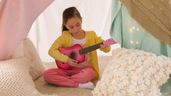 Girl with Toy Guitar Playing in Kids Tent at Home