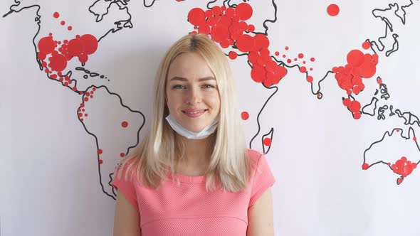 Happy Girl Victorious Coronavirus Smiles and Looks Into Camera Amid a Map of Spread of Coronavirus.