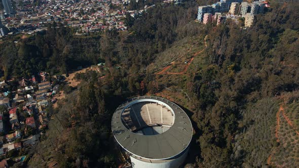 Aerial dolly in of Quinta Vergara Amphitheater, colorful buildings and autumnal trees park in Viña d