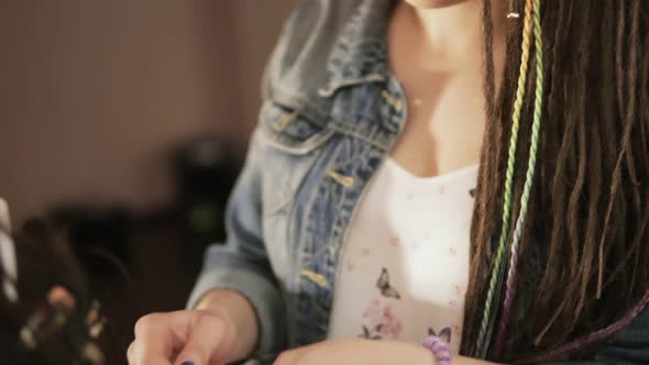 Closeup Portrait of a Female Stylish Hairdresser Doing Dreads for a Young Smiling Woman in the Hair