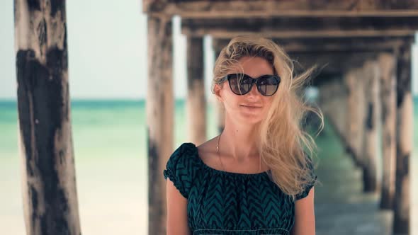 Dreamy Woman Smiling And Relaxing On Beach. Stress Free Girl In Summertime Season Sundress Leisure.
