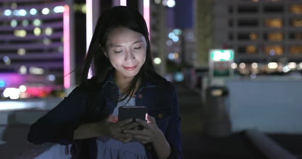 Young woman using mobile phone at night 